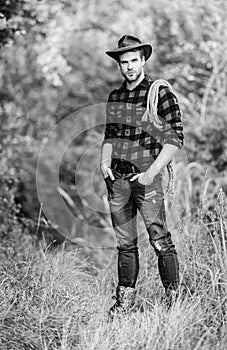 American cowboy. Lasso tied wrapped. Western life. Man cowboy nature background. Man wearing hat hold rope. Ranch owner photo