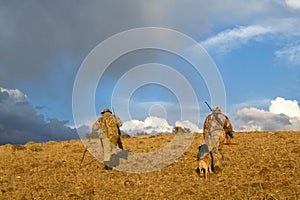 American coyote hunters and dogs in arid sunrise