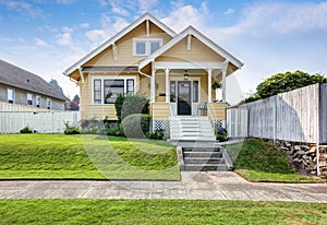 American craftsman home with yellow exterior paint. photo