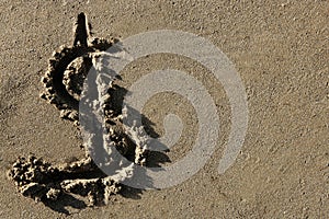 American currency dollar sign on the beach sand