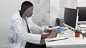 an American doctor carefully examines the MRI images making notes of the record. Modern medicine in lagging countries.