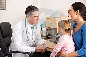 American doctor talking to young child and mother