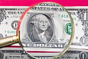 American dollar banknote through a magnifying glass on nice red background