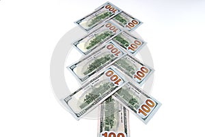 American 100 dollar bills in the form of a Christmas, New Year tree, close-up on a white background, isolated. Money