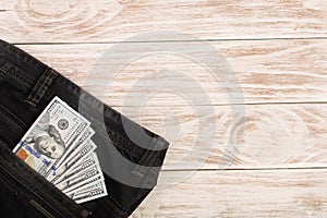 American dollar bills in jeans pocket on white wooden background with copy space for your text. Top view