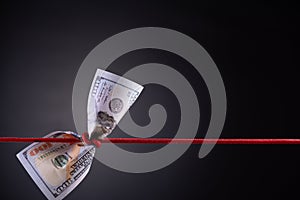 American dollar tied up in red rope knot on dark background with copy space. business finances, savings and bankruptcy concept
