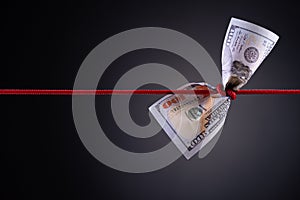 American dollar tied up in red rope knot on dark background with copy space. business finances, savings and bankruptcy concept