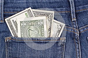 American dollars banknotes peeking out of blue jeans back pocket. Money, personal finance, tax concept