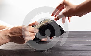 American dollars cash money in black leather wallet on white background, selective focus