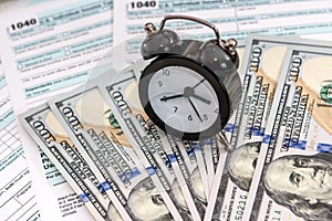 American dollars with clock over individual tax form