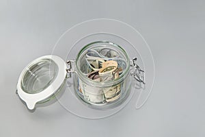 American dollars in a glass jar. Banknotes in a piggy bank. Save money. Financial concept