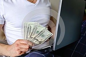 American dollars in hand,laptop computer