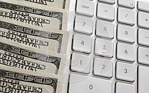 American dollars near computer keyboard calculator