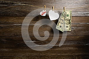 American dollars in two banknotes and hearts for big sale hanging with clothespins. Holiday sale