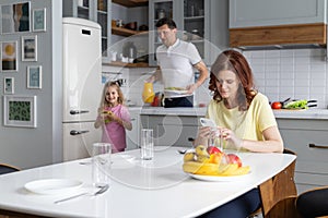 An american dream friendly family in the kitchen in a joyful mood prepare for lunch together. A young man father and