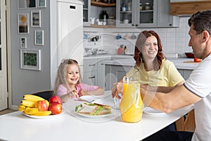 An american dream friendly family in the kitchen in a joyful mood prepare for lunch together. A young man father and