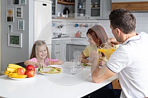 An american dream friendly family in the kitchen in a joyful mood prepare for lunch together. A young man father and