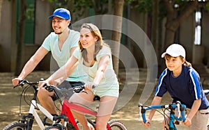 American family cycling in park