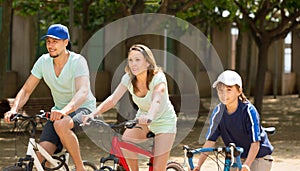 American family riding bicycles in park togetherness