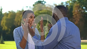 American father and teenage son arguing outdoors, family conflict, communication