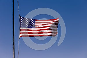 American flag blowing on blue sky at half mast in New York, september 11, USA