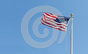 American flag on the blue sky background, turned to the left