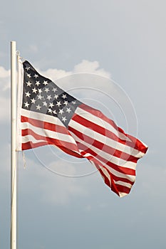 American flag on a blue sky with clouds background