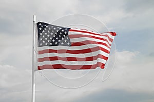 American flag on a blue sky with clouds background