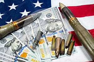 American flag with dollars money, bullets, shells, cartridges and projectiles on it. Lend-Lease concept.  Army concept. Sales of