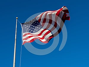 American flag on flagpole with blue sky