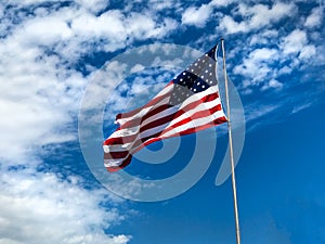 American Flag Flying against bright blue sky horizontal