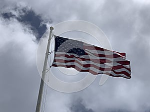 an american flag flying in the sky on a windy day