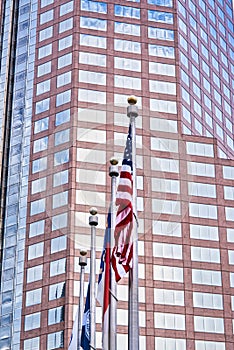 American flag in front of a skyscraper.