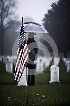 An American Flag on a Gravestone for Veteran\'s Day, Mourner with Umbrella
