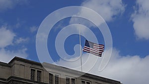 American Flag at half mast over a commercial building