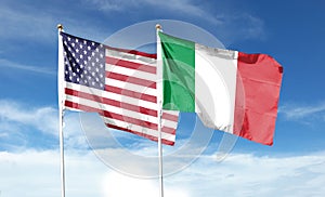 American flag and Italian flag on cloudy sky.