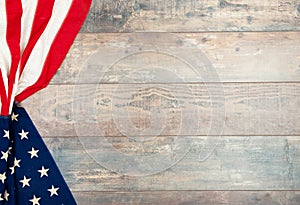 American flag lying on an aged, weathered rustic wooden background