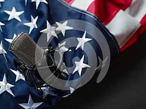 American flag and microphone. Simple gray background. There are no people in the photo. Color image. Close-up. Careful viewing.