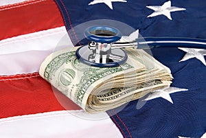 American flag with pile of cash and stethoscope