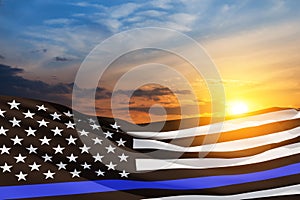 American flag with police support symbol Thin blue line on sunset sky.