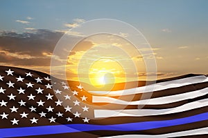 American flag with police support symbol Thin blue line on sunset sky.