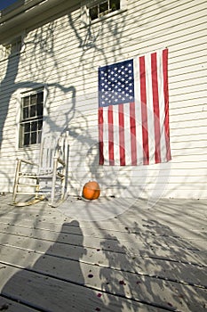 American flag, pumpkin and rocking chair on porch of home in Newport, Rhode Island