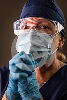 American Flag Reflecting on Concerned Praying Female Medical Worker Wearing Protective Face Mask and Goggles
