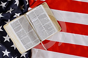 American flag ruffle with open is reading Holy Bible book with prayer for america over US flag