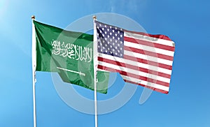 American flag and Saudi Arabia flag on cloudy sky.