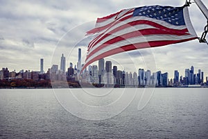 American flag and scenic view of the New York Manhattan skyline as seen from the Hudson River in Edgewater, New Jersey