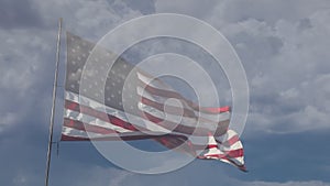 American flag slow motion waving in wind with ghosted time-lapse clouds