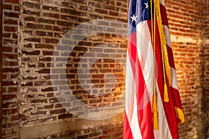 American Flag on Stand, against old brick wall photo