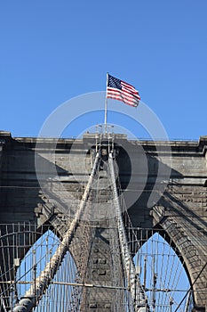 American flag on top of famous Brooklyn Bridge