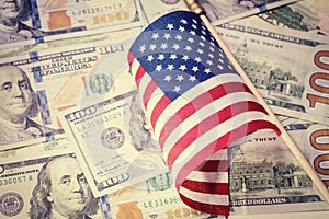 American flag on US dollar bills background. Financial concept. Vintage look.